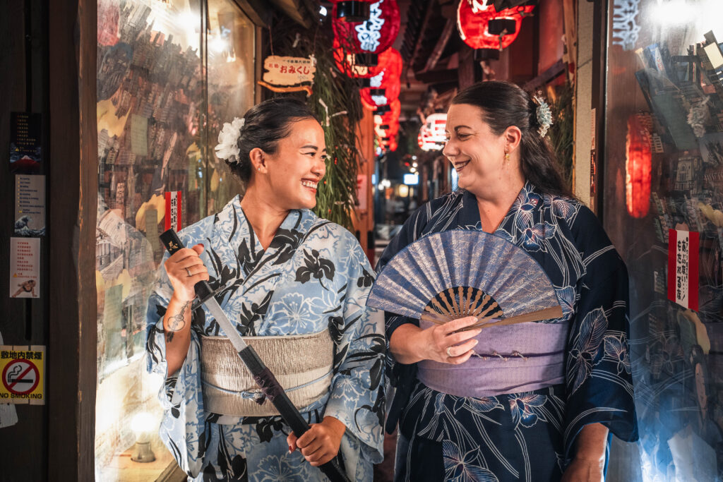 two female travelers in kimono walking and talking in Osaka