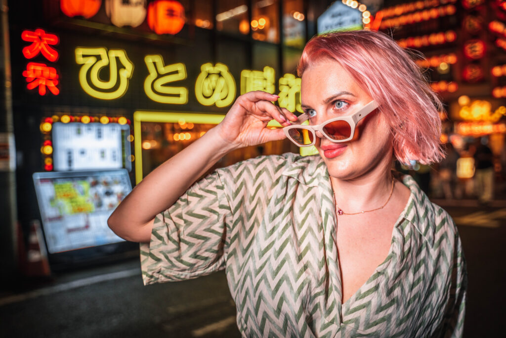 female portrait posing in front of neon signs in Osaka at night