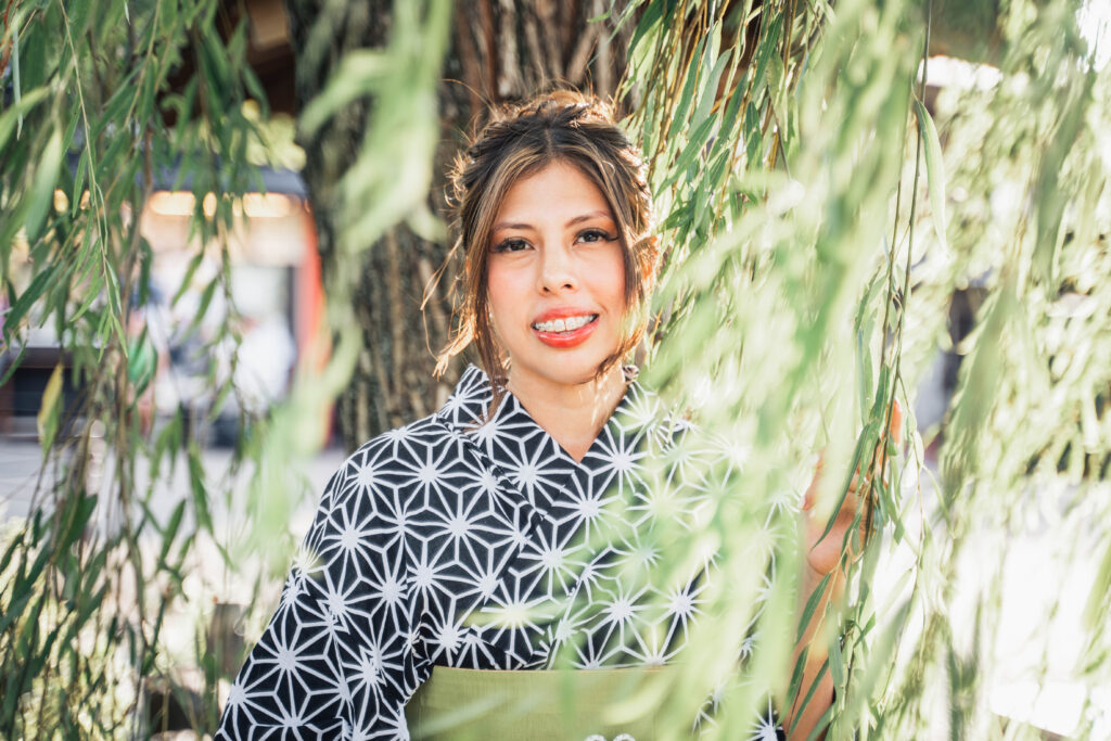 smiling female in kimono surrounded by nature in Kyoto