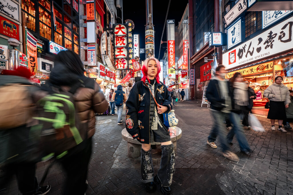 solo traveler standing in the middle of Osaka street at night